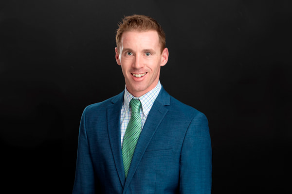 Professional headshot of Mike Kelly in a blue suit